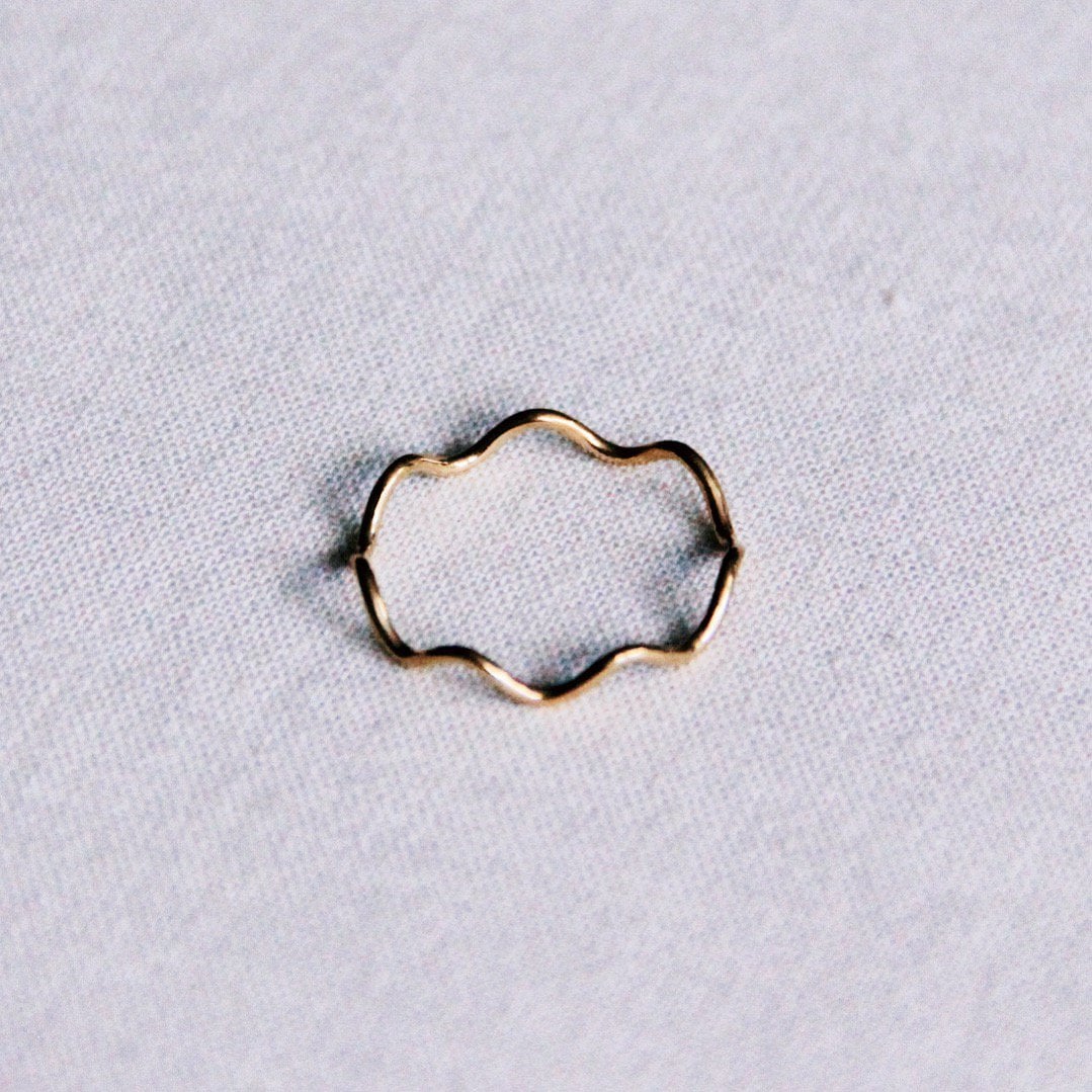 Gold stainless steel minimalist golf ring by Bazou featuring a sleek, modern design on a plain background.