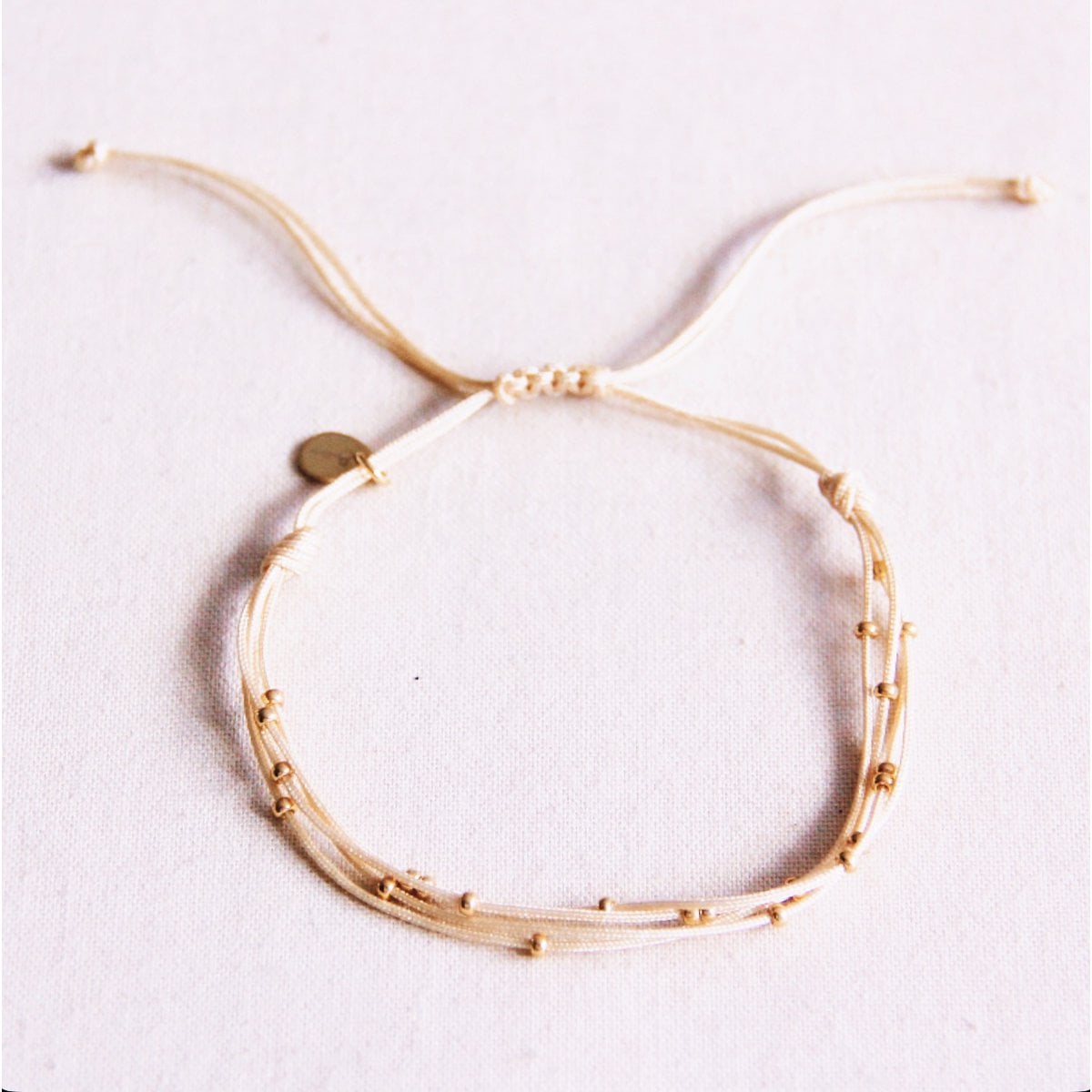 Vierdubbele satijnen armband met kralen - zand - Selva & Co