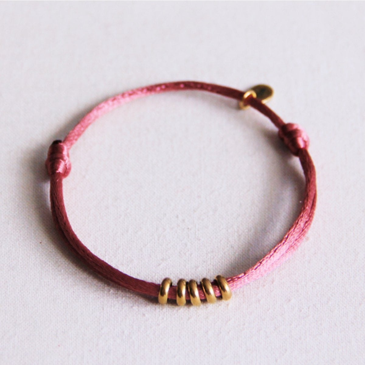 Satijnen armband met ringen – oudroze/goud - Selva & Co