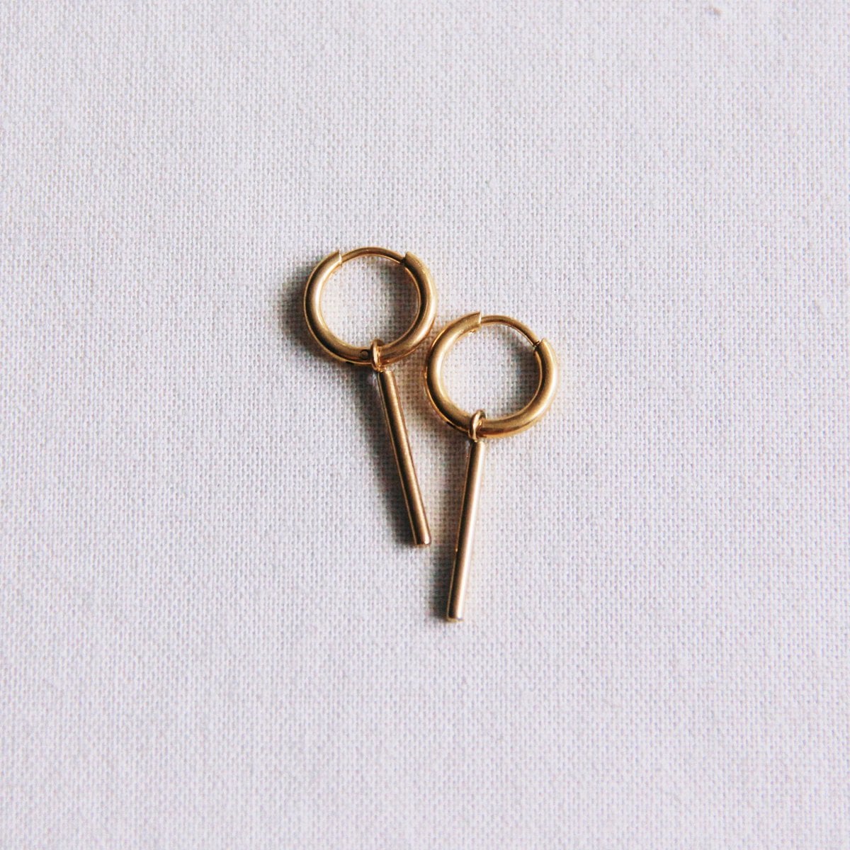 Gold stainless steel hoop earrings with bar detail, stylish and modern jewelry by Bazou.