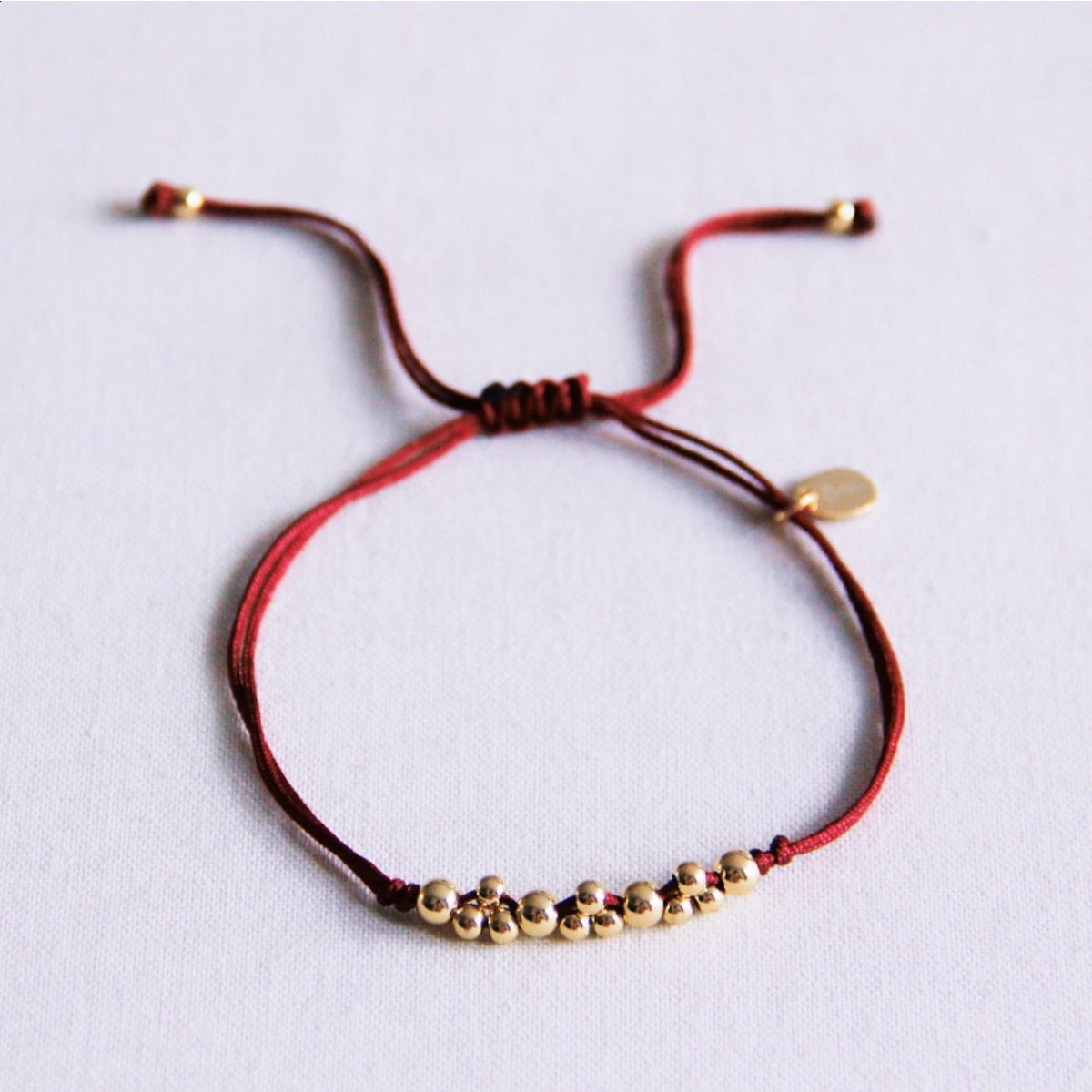 Satijnen armband met goudkleurige kralen - bordeaux - Selva & Co