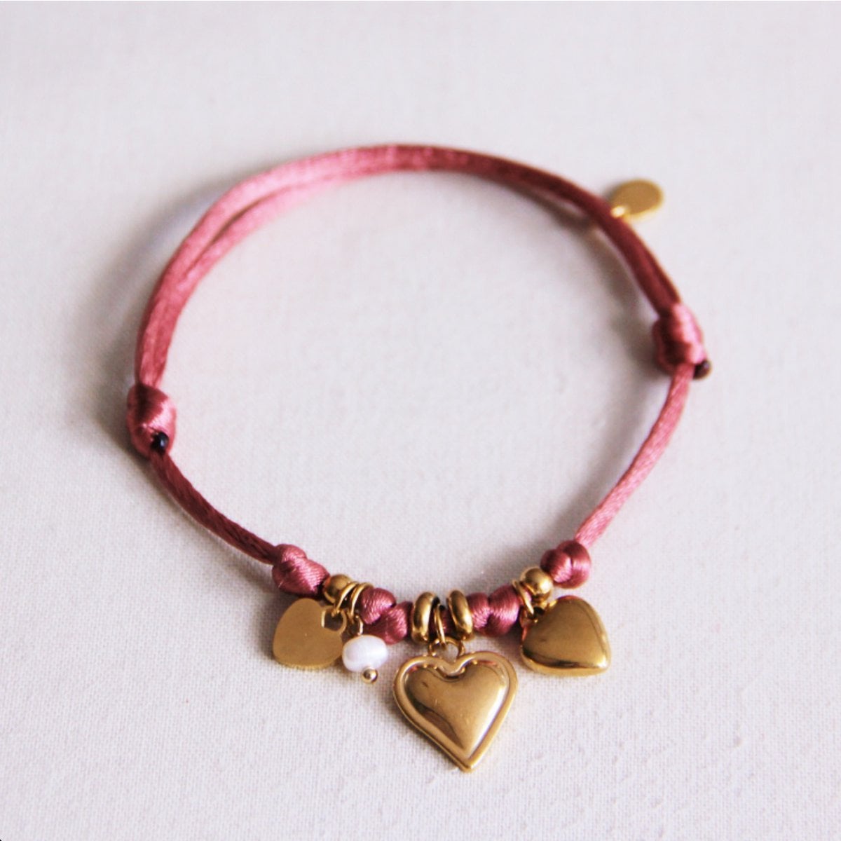 Satijnen armband met hartjes en kleine parel - roze - Selva & Co