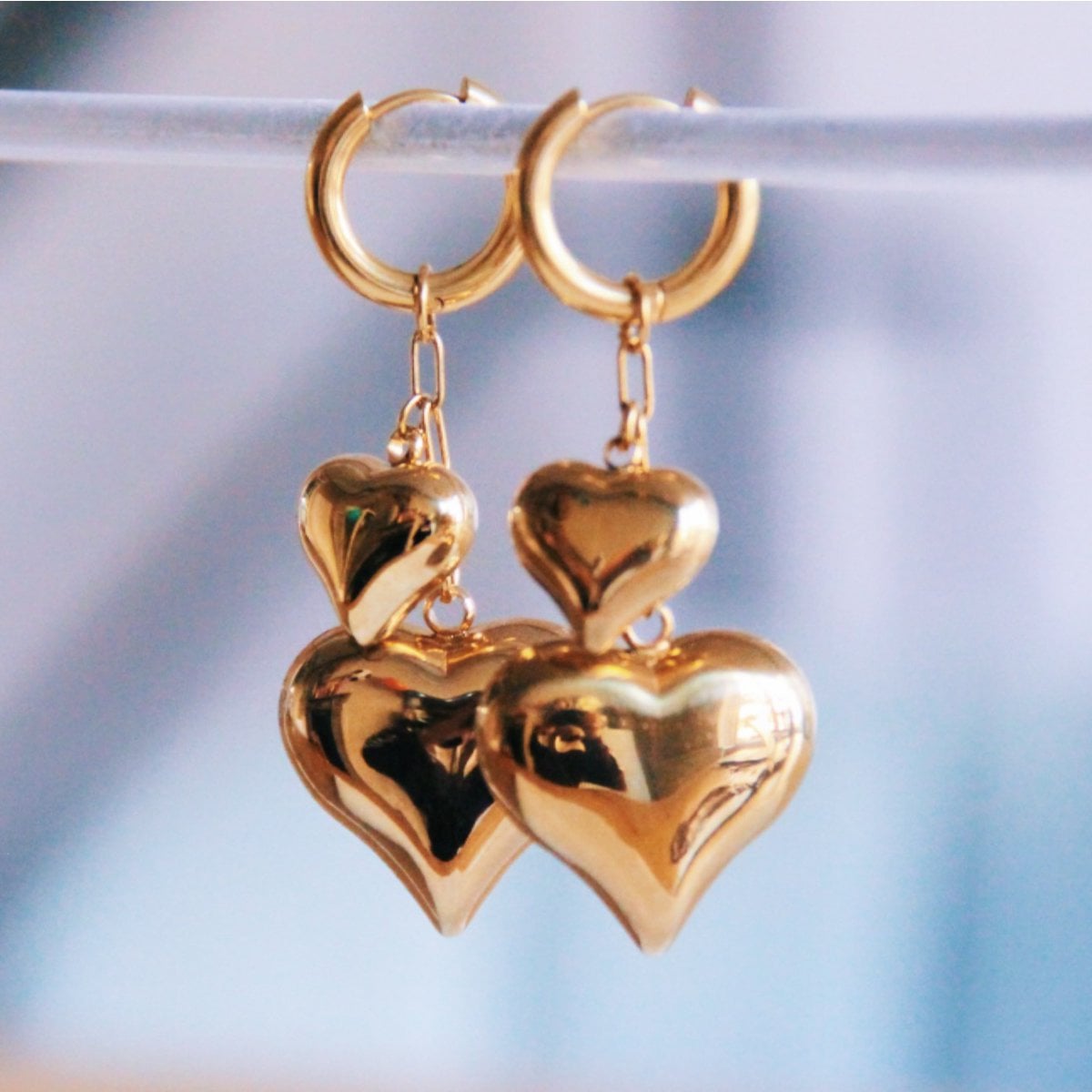 Brede oorringen van roestvrij staal met ketting en hartjes - goud - Selva & Co