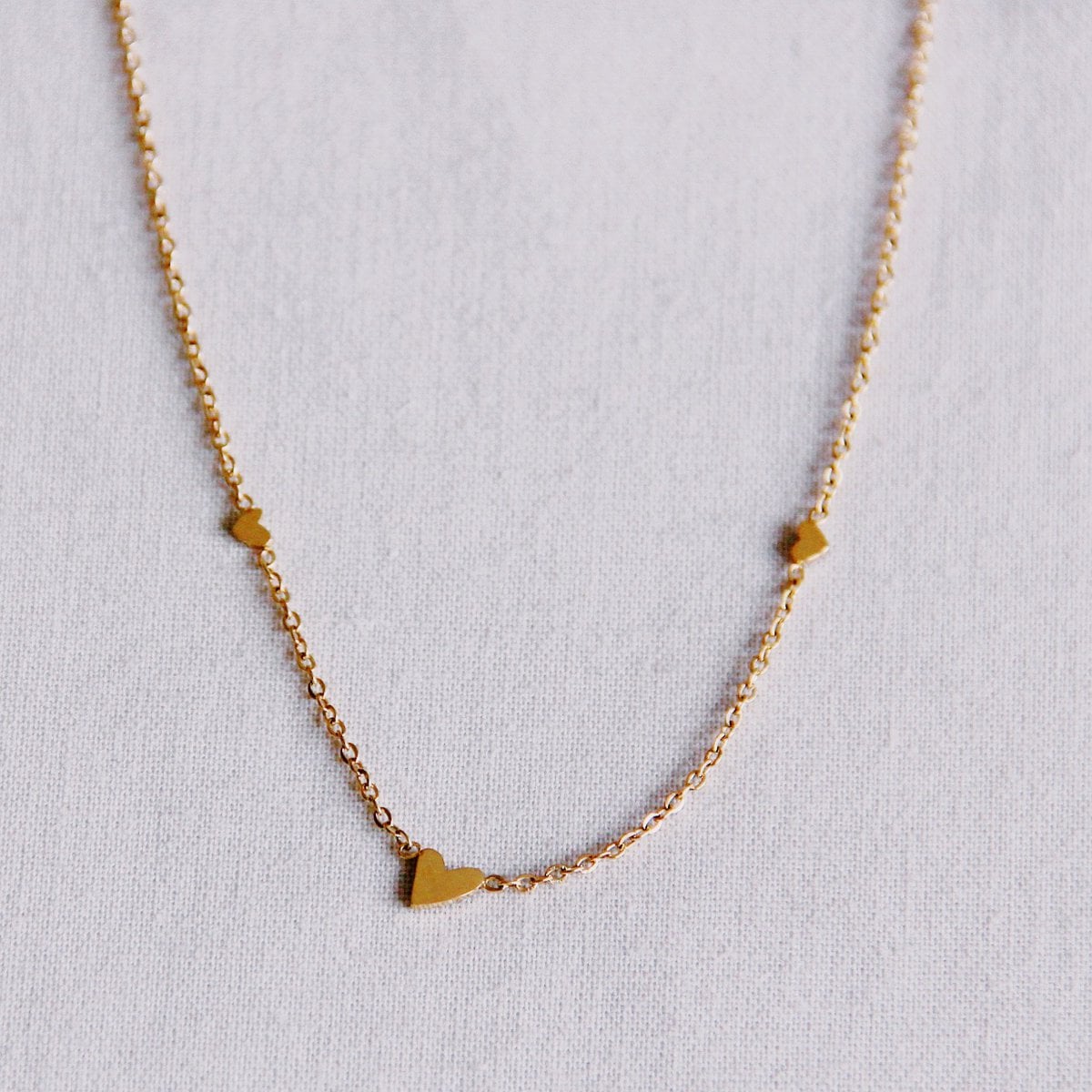 Fijn roestvrijstalen ketting met 3 mini hartjes - goud - Selva & Co